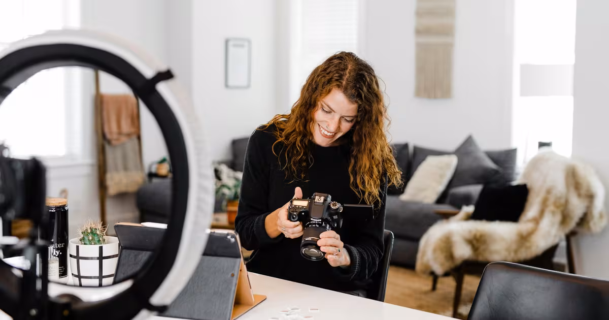 Beauty content creator filming a skincare routine at a bright vanity with a ring light and a product flatlay in soft natural light.