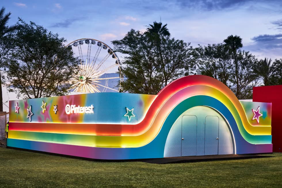 The rainbow-painted exterior of Pinterest's Coachella activation with the Ferris wheel beyond.